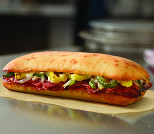 Italian Sandwich - Pepperoni, salami, and ham topped with banana peppers, fresh green peppers, fresh onions, and provolone cheese. On artisan bread and baked to a golden brown.