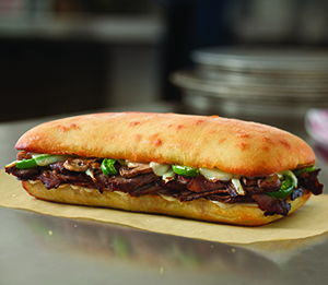Philly Cheese Steak Sandwich - Experience deliciously tender slices of steak, American and provolone cheeses, fresh onions, fresh green peppers and fresh mushrooms placed on artisan bread and baked to golden brown perfection.